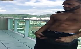 Beautiful guy stroking his cock in the balcony