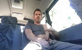 Sexy stud stroking his huge cock in a van