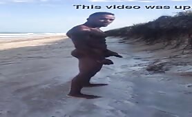 Muscular black shows off his huge cock on the beach